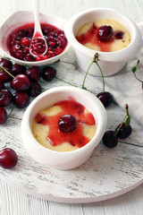 Tasty pudding with cherries on table close up