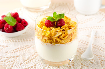 Breakfast with cereal flakes, yogurt and fresh raspberries
