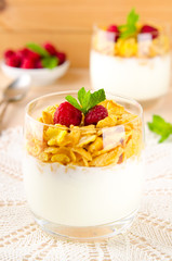 Breakfast with cereal flakes, yogurt and fresh raspberries