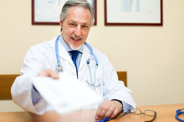 Portrait of a doctor giving a document to a patient