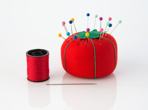 Close up of sewing tools. Red pin cushion with many colorful stick pins and  needles. Short pieces of thread. Metal thimble. All on black background  Stock Photo - Alamy