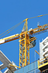 Crane and building construction site against blue sky