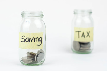 Jar for savings and taxes full of coins.