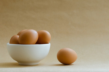 Eggs In White Bowl On Brown Background.