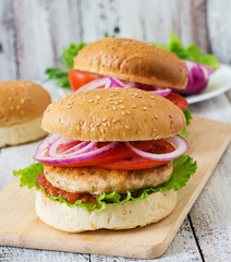 Sandwich with chicken burger, tomatoes, red onion and lettuce