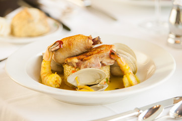 Shrimp and clam seafood appetizer on a white plate.
