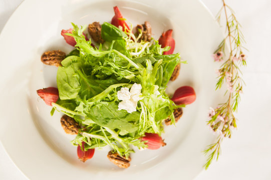Fancy healthy salad on a white plate.