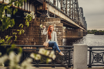 Obraz na płótnie Canvas Redhead casual girl posing near big river.