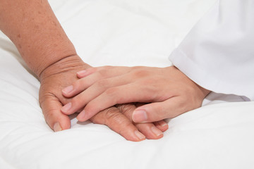 Fototapeta na wymiar Doctor holding an old woman's hand