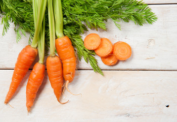 Fresh washed carrots on white wooden table