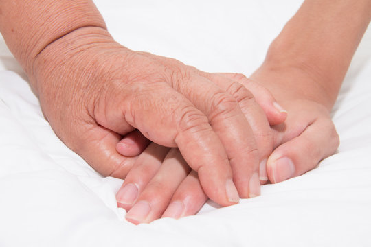 Elderly woman holding a young hand