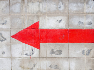 Red turn left arrow on the old wall cement.