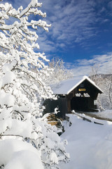 Covered bridged blanketed in fresh snow on a sunny winter mornin