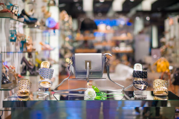 Woman luxury shoes and leather bag on shine table in shoes store