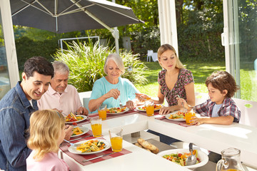 Familie beim Mittagessen zu Hause im Sommer