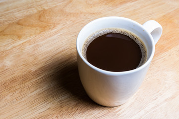 Cup of coffee on wooden table.
