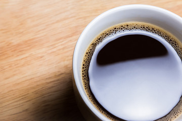 Cup of coffee on wooden table. Close up shot.