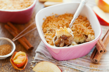 Apple crumble with cinnamon on rustic wooden table