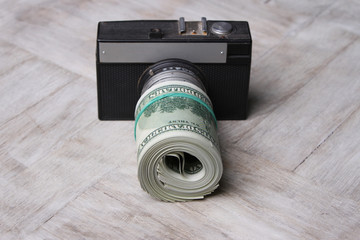 Conceptual photo for microstock photography, making money by camera shooting. Camera and Money