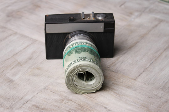 Conceptual photo for microstock photography, making money by camera shooting. Camera and Money