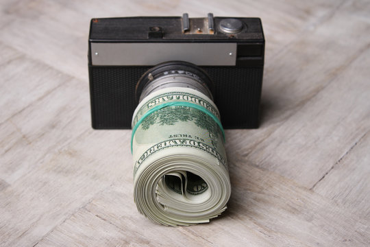 Conceptual photo for microstock photography, making money by camera shooting. Camera and Money