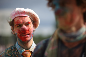 Portrait of a displeased clown in a beret splattered with paint