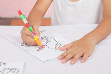 Asian boy Sitting coloring homework teachers assign.