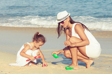 Naklejka premium Mother and daughter playing on the beach at the day time.
