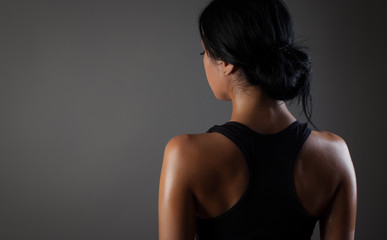 Fototapeta na wymiar Rear view of strong young woman wearing sports bra