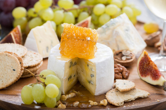 camembert with honey and fruit, snacks on a wooden tray