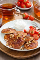 Pancakes with fresh strawberries and cream, jam and tea 