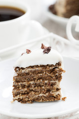 piece of coffee cake with icing on white plate, vertical