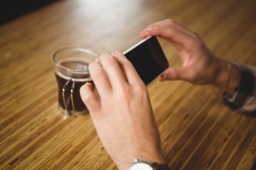 Man photographing his cup of coffee