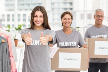 Smiling volunteers holding donation boxes