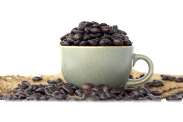 Stock Photo:.Cup full of coffee beans on the cloth sack