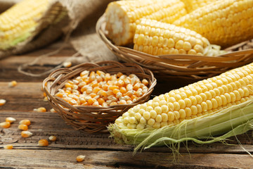 Corns in basket on a brown wooden background