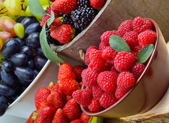 Blackberries, strawberry, raspberry and grapes in a wooden baske