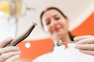 Dentist with a drill and medical mirror