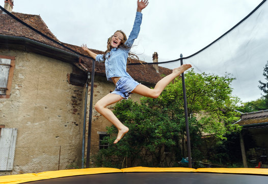 Cute teenage girl jumping on trampoline