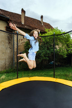 Cute teenage girl jumping on trampoline