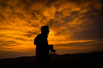Obraz premium Photographer silhouette at sunset