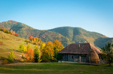 Fototapeta na wymiar An old house in a very beautiful autumn rural landscape