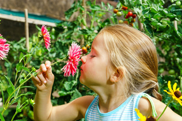 Naklejka premium Cute preschooler girl portrait with natural flowers