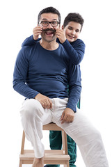 Cute boy pulling his father's mustache isolated.