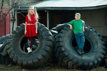 Naklejka na ściany i meble children playing in junkyard tires