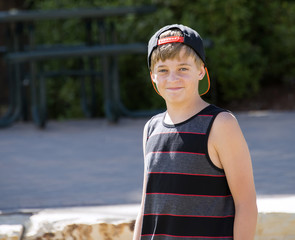 A Happy Teenage Boy in a Cap Smiles for a Portrait