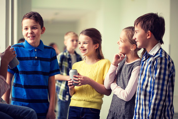 group of school kids with soda cans in corridor