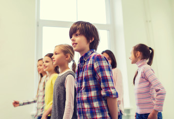 group of smiling school kids walking in corridor