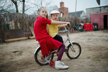 children ride on bicycle in yard