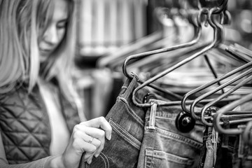 Beautiful blonde female looking jeans in the boutique